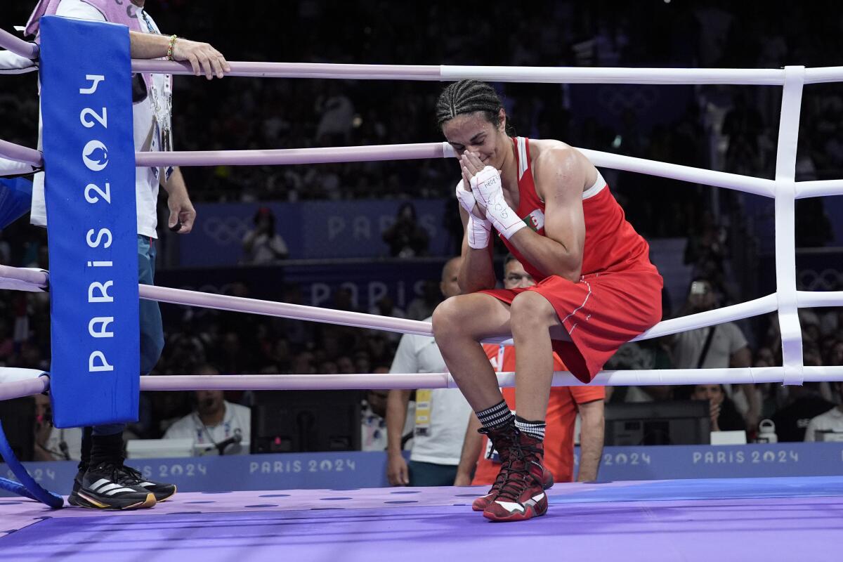 Algeria's Imane Khelif holds her hands to her face and shows emotion after defeating Hungary's Anna Hamori 