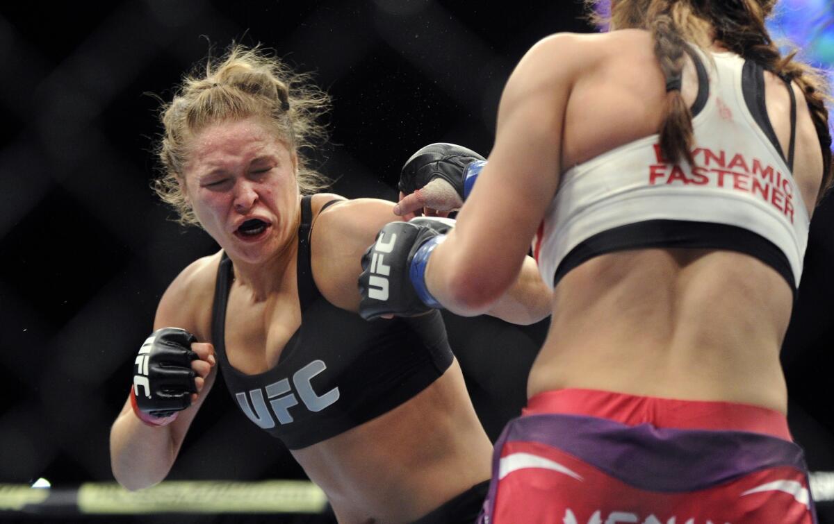 Ronda Rousey, left, jabs Miesha Tate during their bantamweight title fight at UFC 168 in Las Vegas on Saturday.