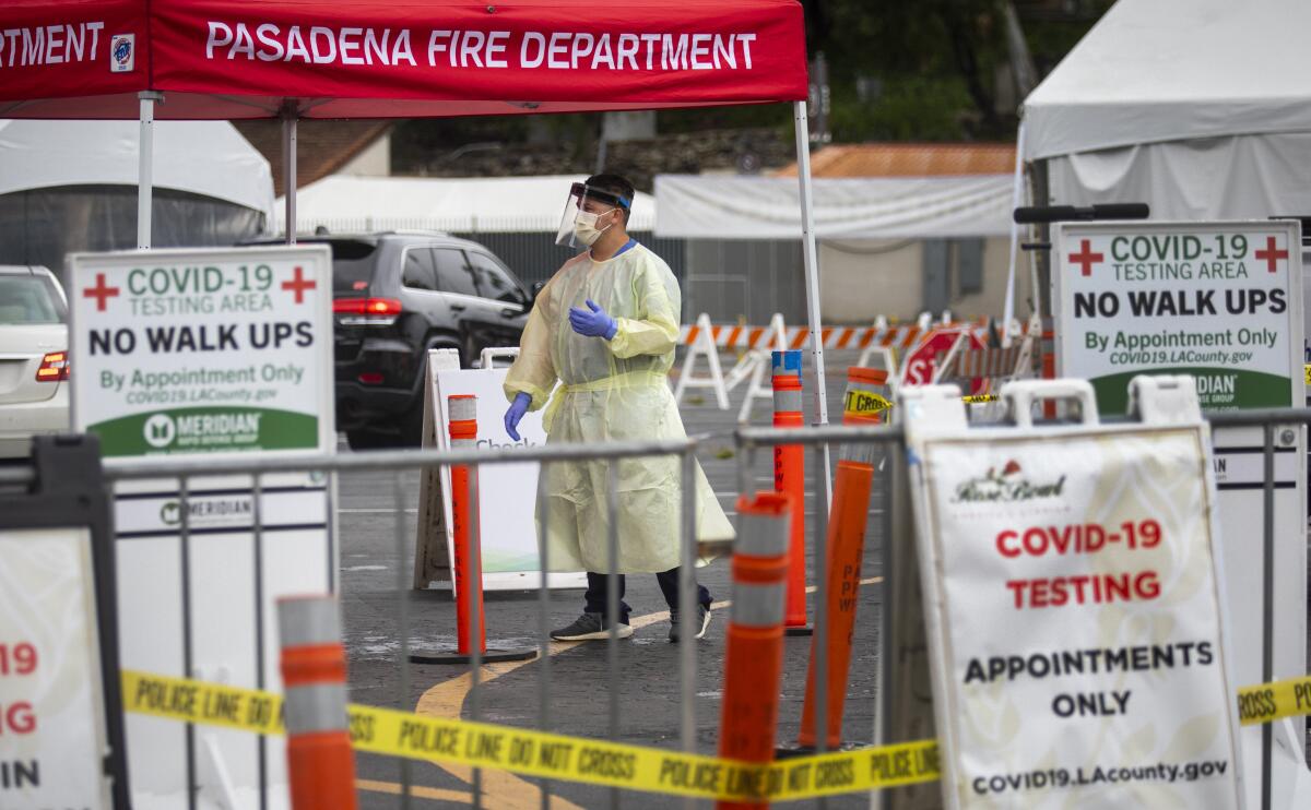 Healthcare worker speak with drivers at a coronavirus testing site in Pasadena in May.