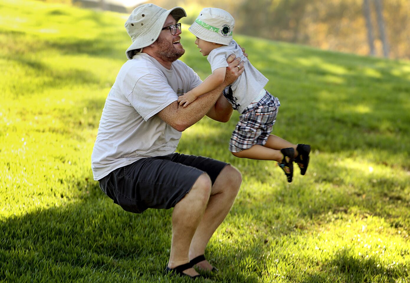 Brannigan Cheney picks up his son Atlas, 2, after cooling off in the shade on the grounds of the George C. Page Museum in Los Angeles.