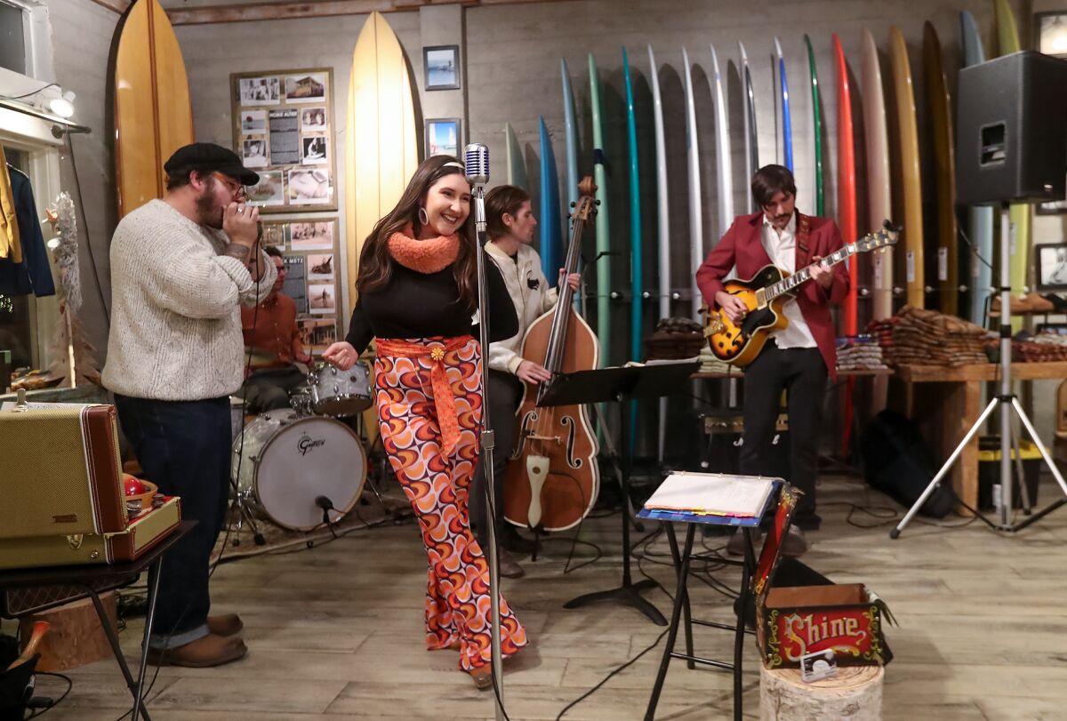 Members of the band Moonshine perform at Hobie Surf Shop during Hospitality Night in downtown Laguna Beach on Friday.