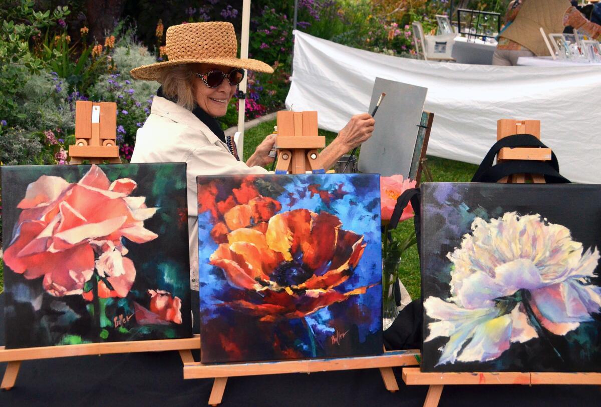Laguna Beach artist Carole Boller begins a painting behind her display of giclée prints.