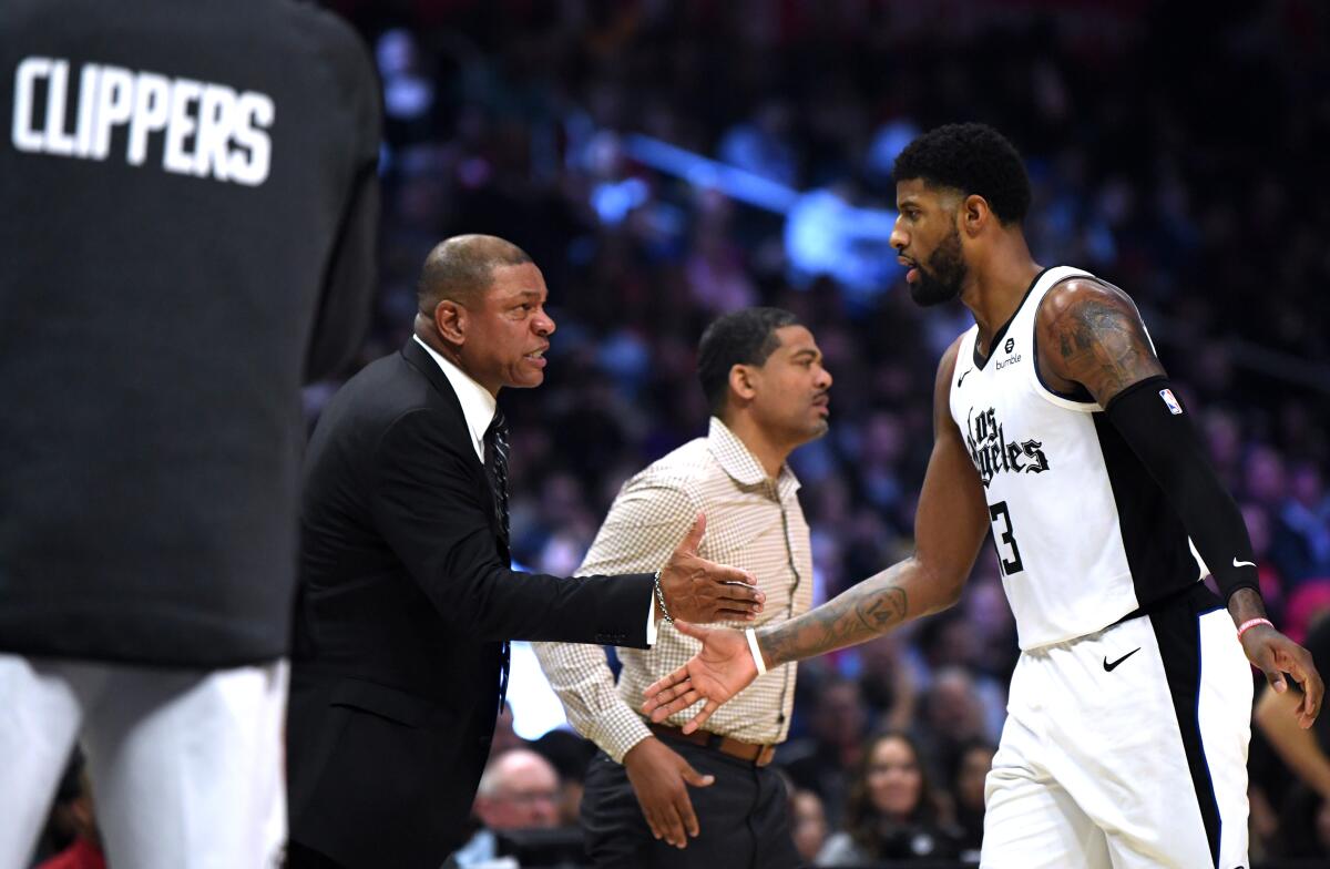 Clippers coach Doc Rivers congratulates forward Paul George after he made a three-point shot against the Rockets during a game earlier this season.