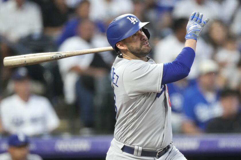 Los Angeles Dodgers' J.D. Martinez follows the flight of his two-run home run off Colorado Rockies.