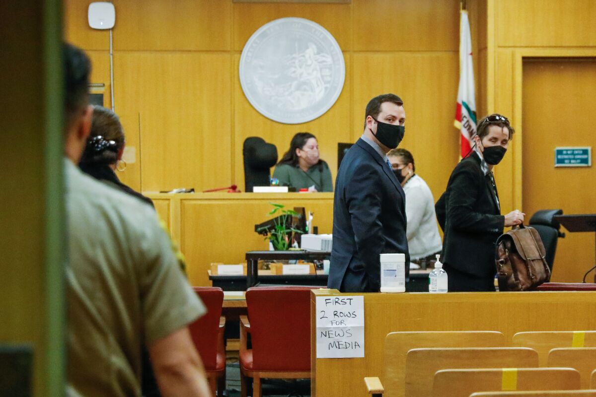 People wearing masks walk into a courtroom