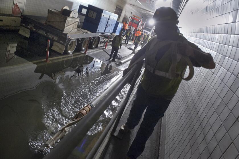 Employees from New York's Metropolitan Transportation Authority pump water out of the Brooklyn-Battery Tunnel.