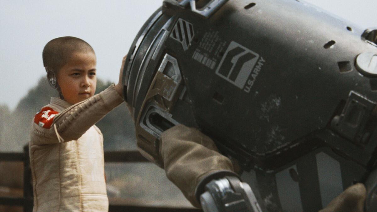 A child touches a robot.