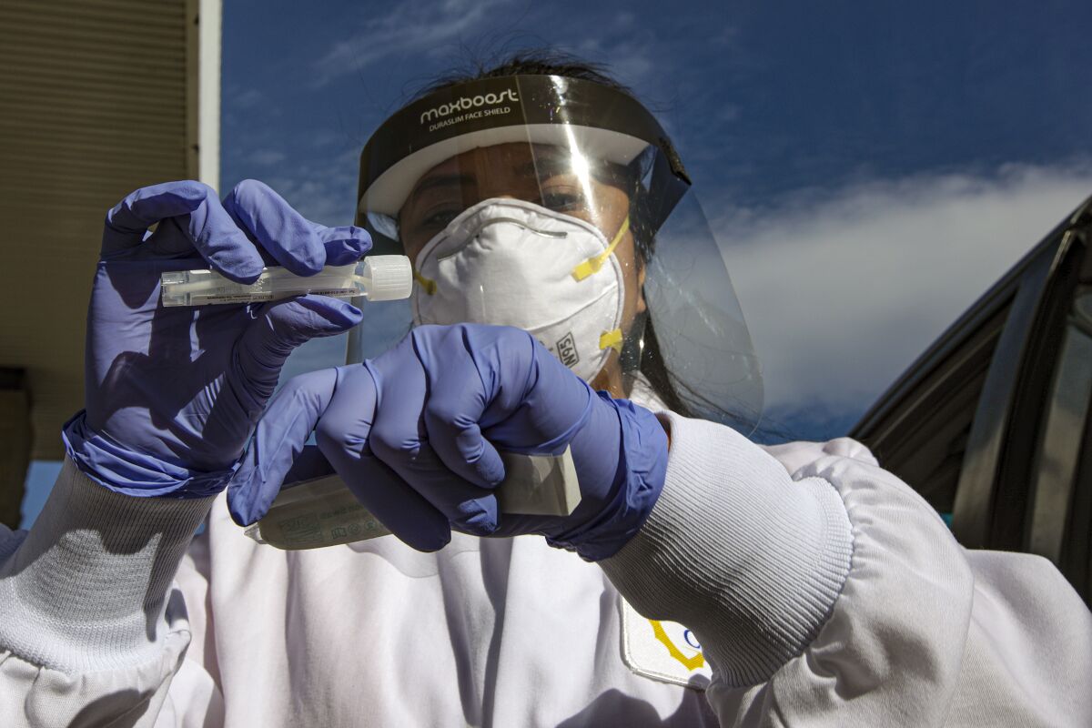 A San Bernardino County Public Health Department nurse collects a nasal sample for coronavirus testing.