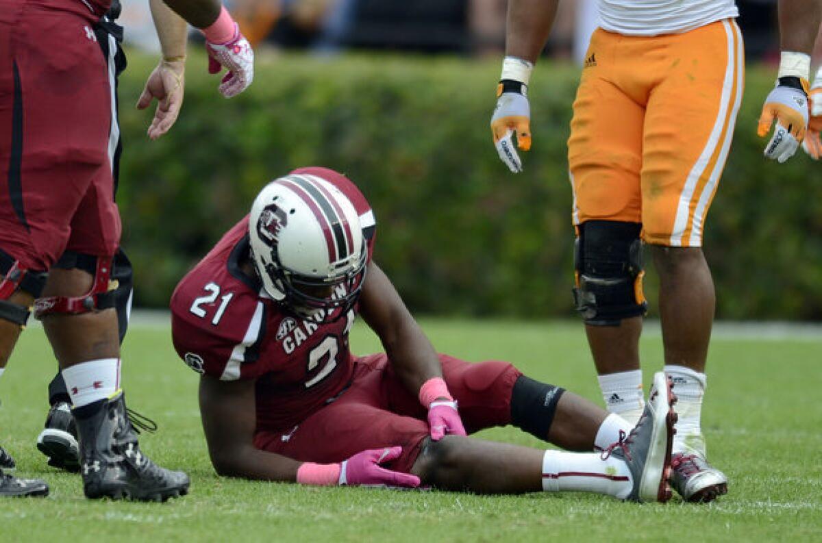 South Carolina running back Marcus Lattimore grabs his right knee after being hit by Tennessee's Eric Gordon during the first half Saturday.