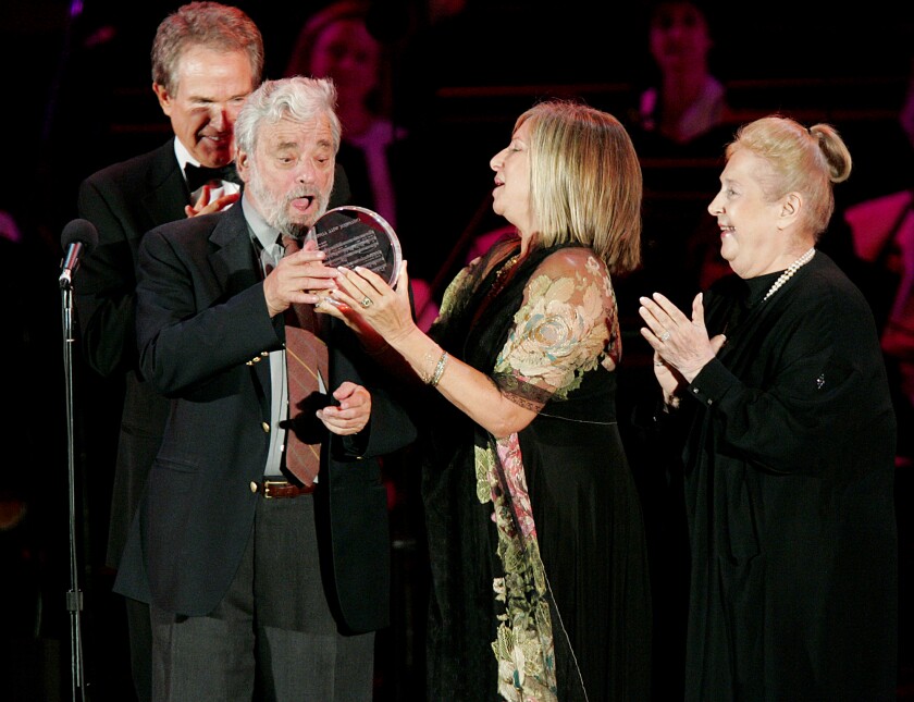 Stephen Sondheim receives a crystal sculpture from Barbra Streisand under the gaze of Warren Beatty and Marilyn Bergman.
