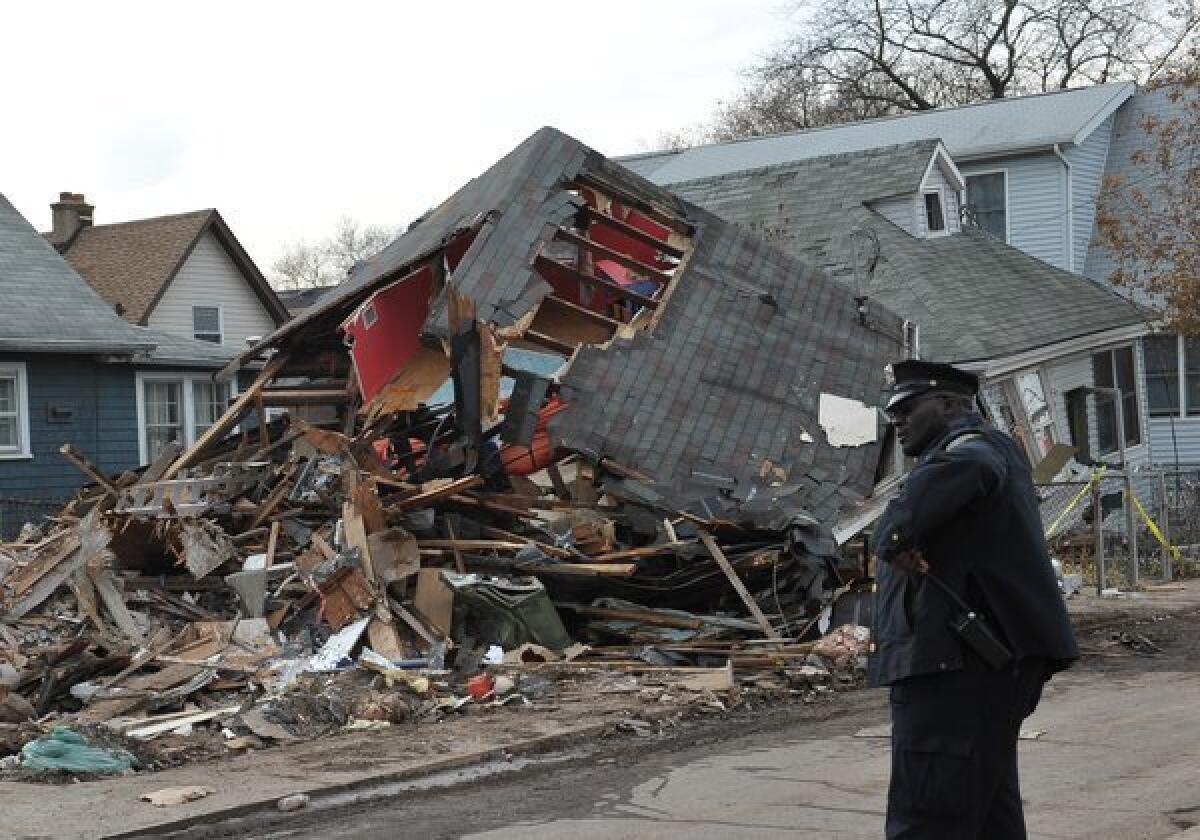 A police officer stands outside a collapsed house on Staten Island. Parts of Staten Island and Long Island remained without power in the aftermath of Sandy.
