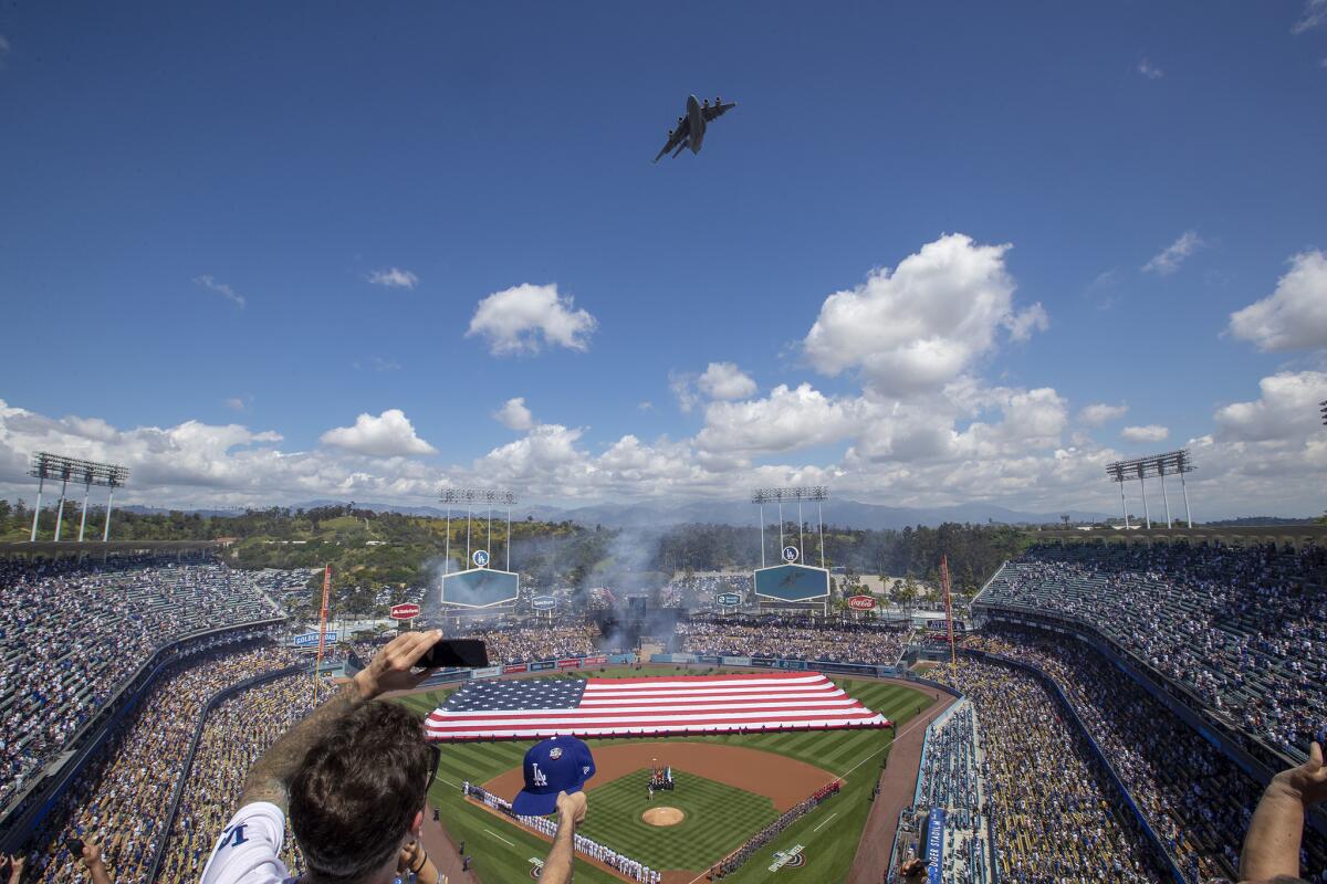A C-17 Globemaster military transport plane flies over Dodger Stadium during the playing of the national anthem prior to the start of Thursday's game against the Arizona Diamondbacks.