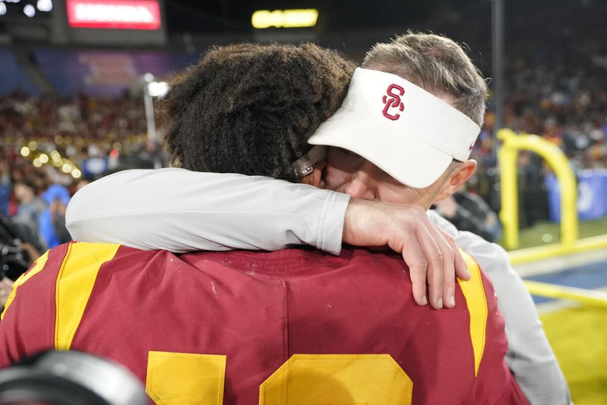USC quarterback Caleb Williams gets a hug from coach Lincoln Riley after the Trojans beat UCLA 