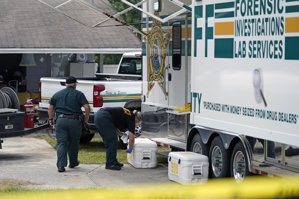 Officers from the Polk County Sheriff Department work outside Tuesday, Sept. 7, 2021, in Lakeland, Fla., at the home where a family of four was shot and killed. (AP Photo/John Raoux)