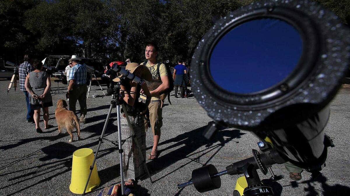 Visitors to the Mt. Wilson Observatory view a partial eclipse of the sun through various telescopes in 2014. (Brian van der Brug / Los Angeles Times)