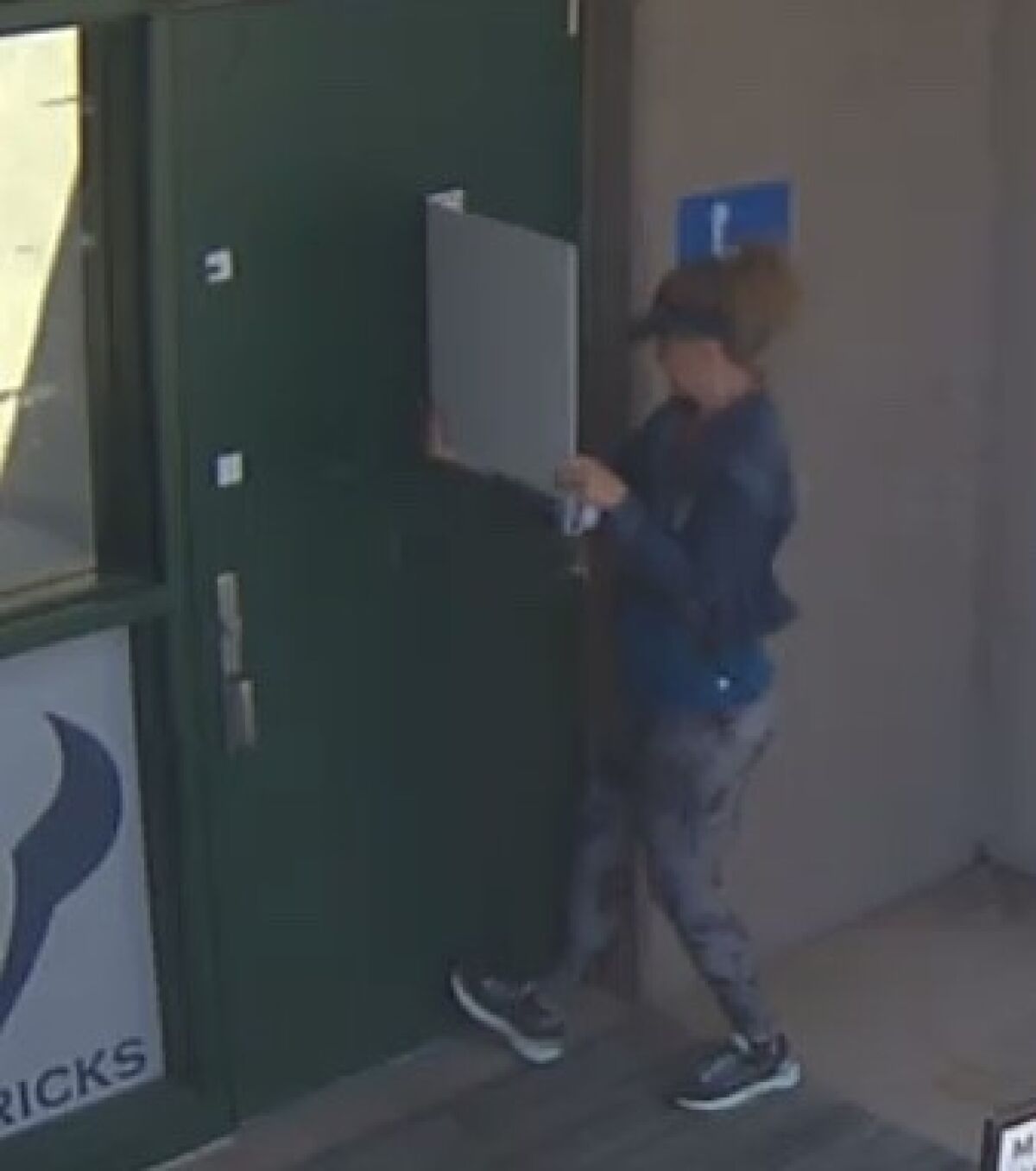A woman rips down a mask mandate poster on the LCC campus.