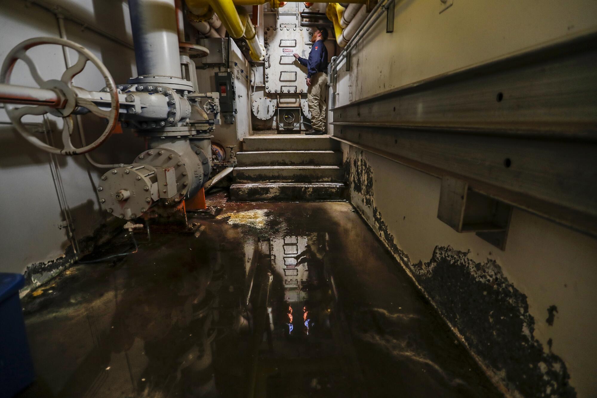 A man stands at the end of a hallway in an Idaho dam.