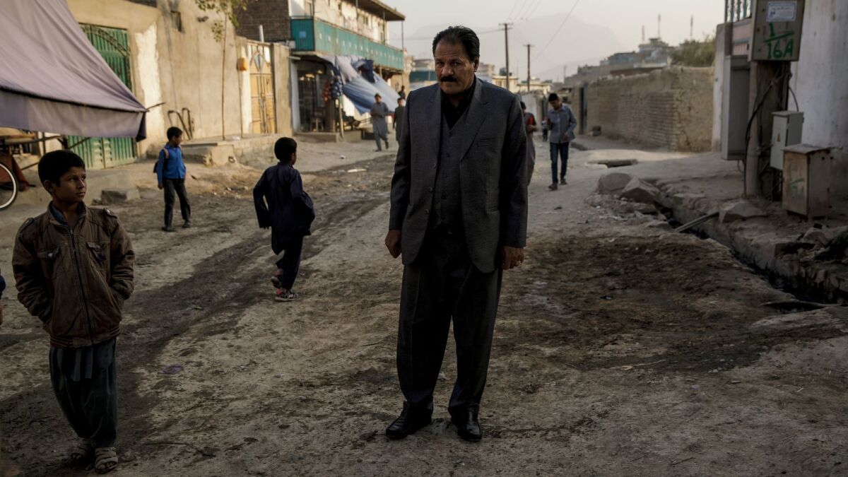 Col. Haji Habib Rahman, father of the slain Almar Habibzai, stands over the site where his son was killed outside their home in Kabul, Afghanistan.