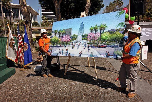 Miguel Balderas, left, and Eduardo Chavez, right, carry away a rendering of the Civic Park after its groundbreaking ceremony. The 16-acre, four-block park in the heart of downtown will stretch from the Music Center to City Hall. The park is the first part of the Grand Avenue Project, a multibillion dollar project to revitalize the area with entertainment venues, restaurants, high-rise condos and retail outlets.