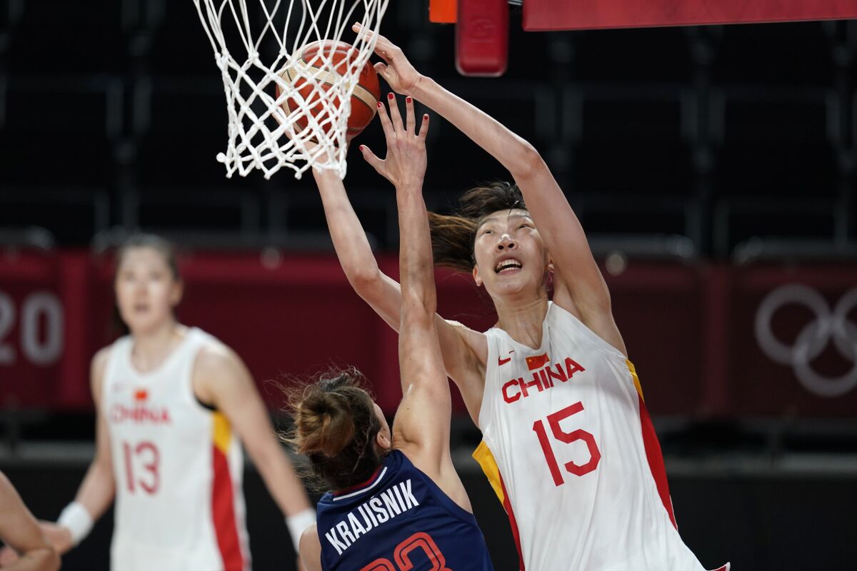 FILE - China's Han Xu (15) shoots over Serbia's Tina Krajisnik during a women's basketball quarterfinal at the 2020 Summer Olympics, Aug. 4, 2021, in Saitama, Japan. After missing the last two seasons while she stayed at home in China, dealing with the COVID lockdowns and training for the Olympics, Han is back in New York. The 22-year-old has grown an inch, standing at 6-foot-10 now and feels more ready to play in the WNBA. (AP Photo/Charlie Neibergall, File)