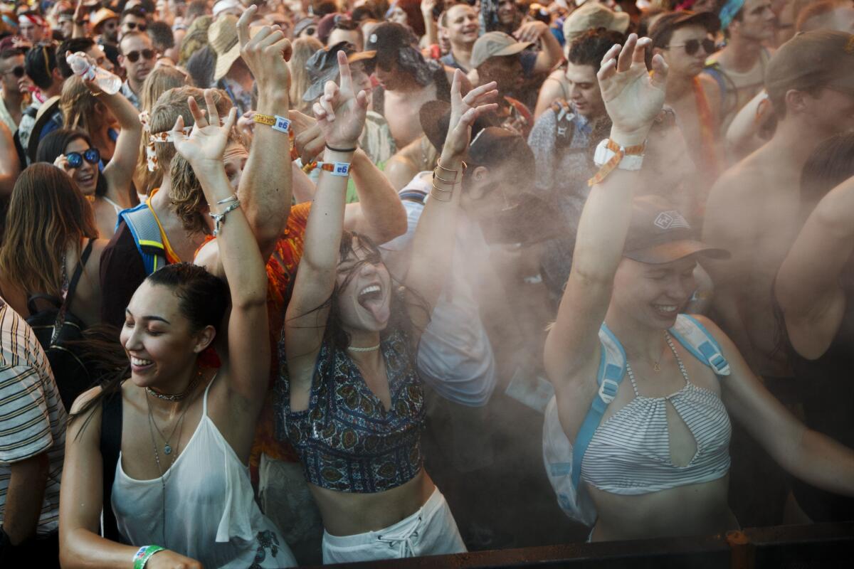 Coachella attendees dance as they are sprayed with mist at the 2017 festival.