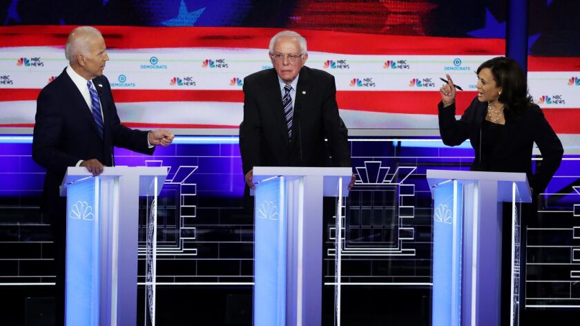 Sen. Kamala Harris, right, and former Vice President Joe Biden spar on either side of Sen. Bernie Sanders during the second night of the first Democratic presidential debate Thursday in Miami.