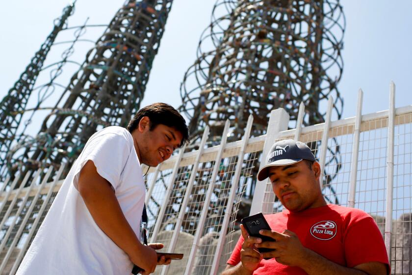 Friends Franco, left, and Kyle play "Pokemon Go" at the Watts Towers.