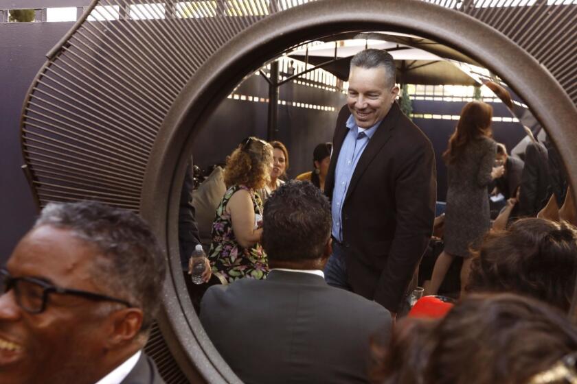 EAST LOS ANGELES, CA - JUNE 21, 2018 - Retired Sheriff Lt. Alex Villanueva, center, reflected in mirror, meets with members of the public during a mixer at ChimMaya Art Gallery in East Los Angeles on June 21, 2018. Lt. Villanueva says he can beat incumbent Jim McDonnell in the election for L.A. County Sheriff in November. McDonnell is in the unusual position of being a sitting sheriff who was forced into a runoff earlier this month. Lt. Villanueva retired earlier this year after serving in the sheriff's department for more than 30 years. Sheriff McDonnell outraised him nearly 22 to one, but Villanueava parlayed his $27,000 war chest into a second-place finish in the recent election with 33 percent of the vote. (Genaro Molina/Los Angeles Times)