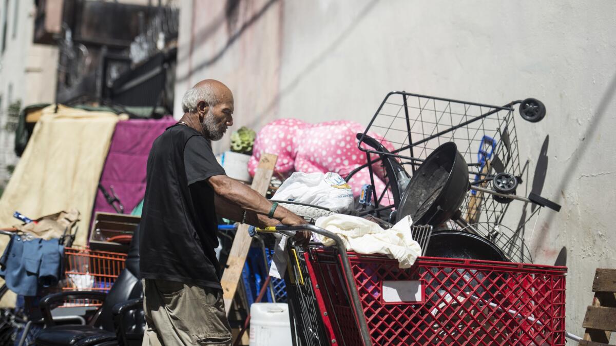 A man called "Cuba," who was Ida Mae Prince's next-door-neighbor, stands in silence near Prince's shelter.