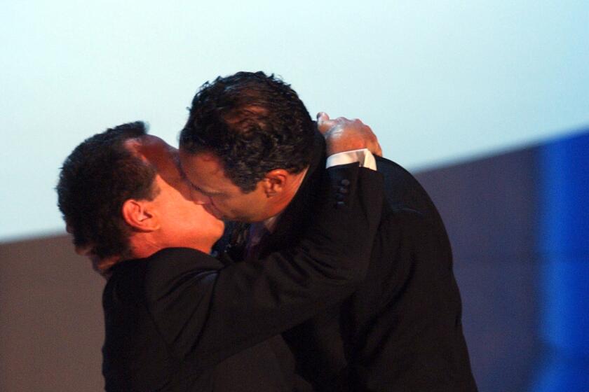 Garry Shandling (L) gets a kiss from Brad Garrett at the 55th annual Emmy Awards at the Shrine Auditorium