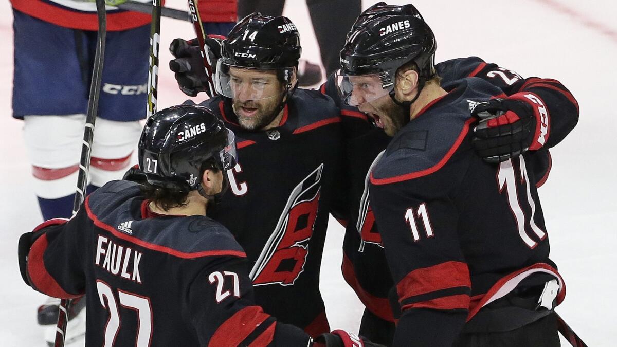 Carolina Hurricanes teammates Jordan Staal (11), Justin Faulk (27) and Justin Williams (14) celebrate Staal's third-period goal against the Washington Capitals on April 22.