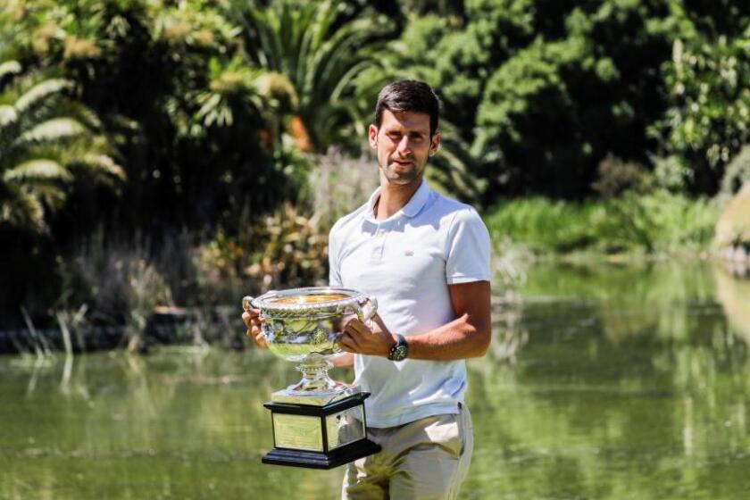 El tenista serbio Novak Djokovic posa con el trofeo tras ganar el Abierto de Australia este domingo. EFE