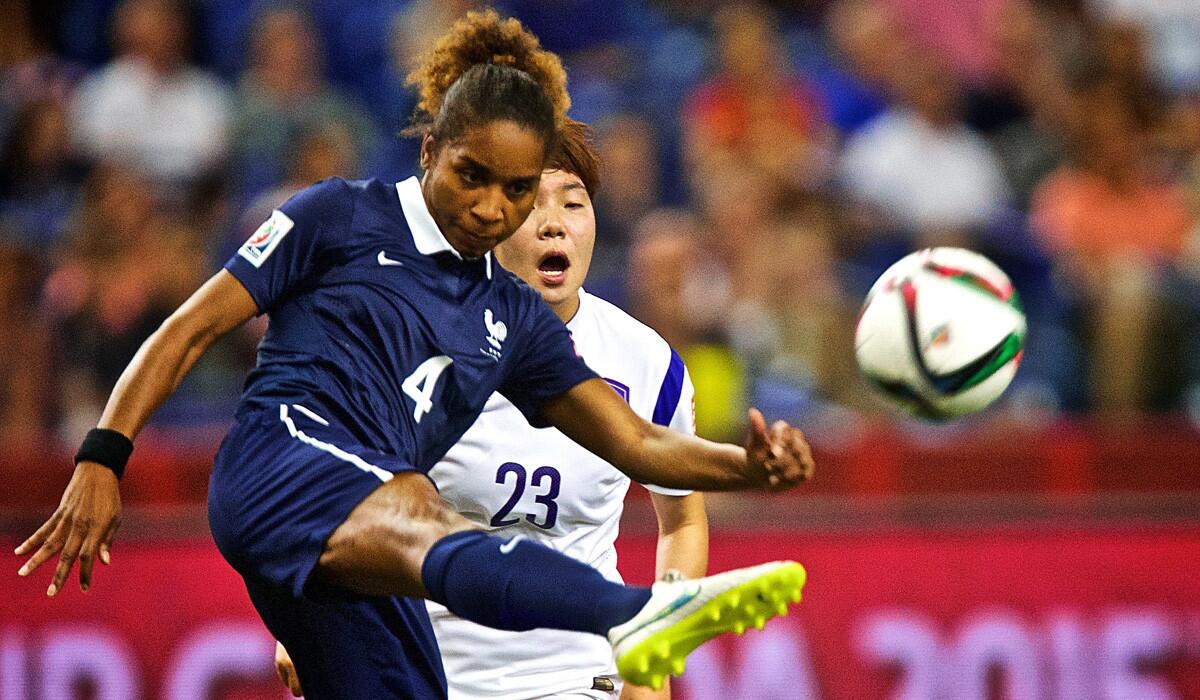 France's Laura Georges, left, kicks the ball away from South Korea's Lee Geummin during the FIFA Women's World Cup 2015 Round of 16 on Sunday. France blanked South Korea, 3-0.