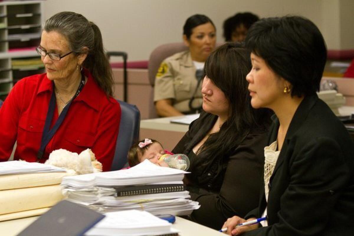 Sabrina Hickman, 18, with her 2-month-old daughter Alauni, is flanked by Victoria Thompson, left, her court appointed special advocate and attorney Ina Tjandrasuwita at Edmund D. Edelman Children's Court in Monterey Park.