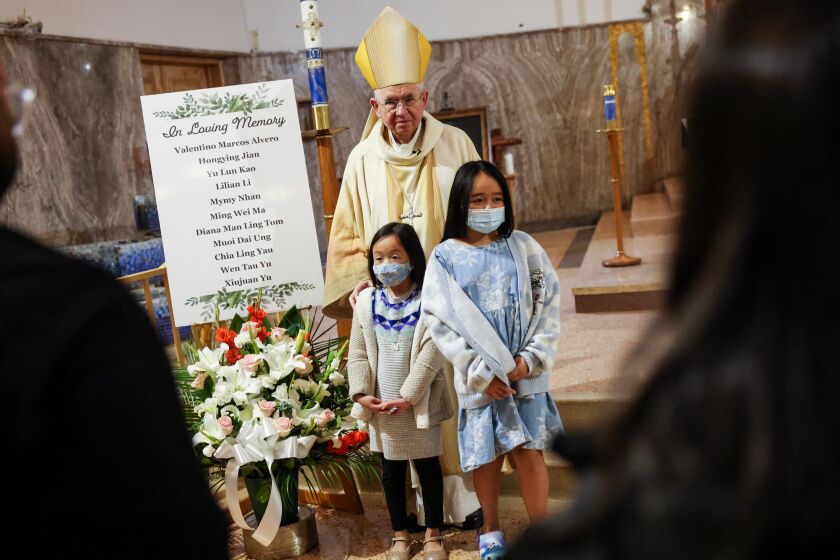 Archbishop Jose H. Gomez takes a picture with children following a mass in memory of the Monterey Park shooting victims