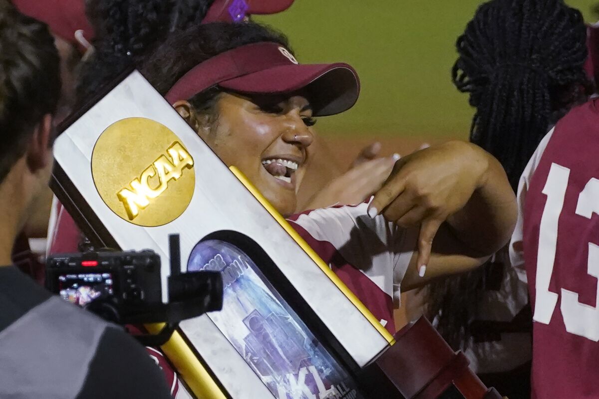 Oklahoma's Jocelyn Alo holds the trophy after Oklahoma defeated Texas in the NCAA softball Women's College World Series finals Thursday, June 9, 2022, in Oklahoma City. (AP Photo/Sue Ogrocki)