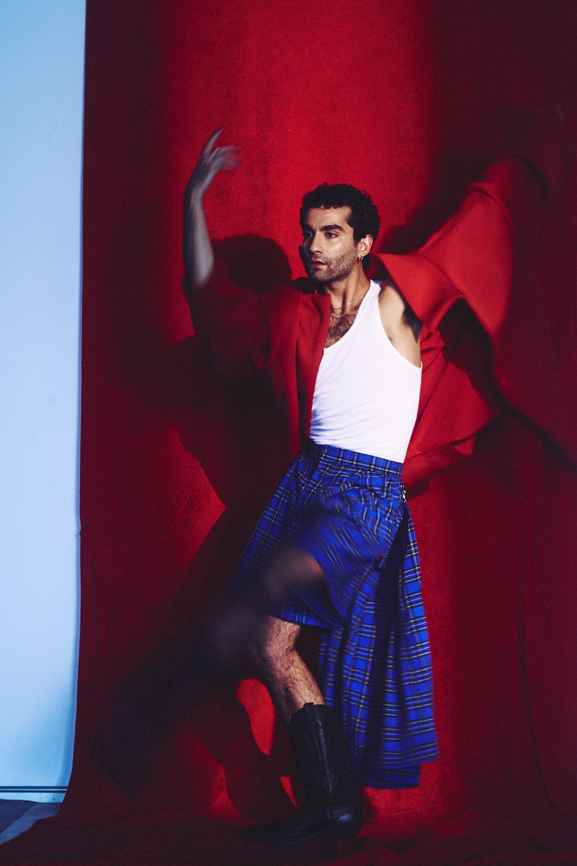 Vinicius Silva wearing a red zoot suit Jacket by Gypsy Sport and blue plaid skirt by Río Original.