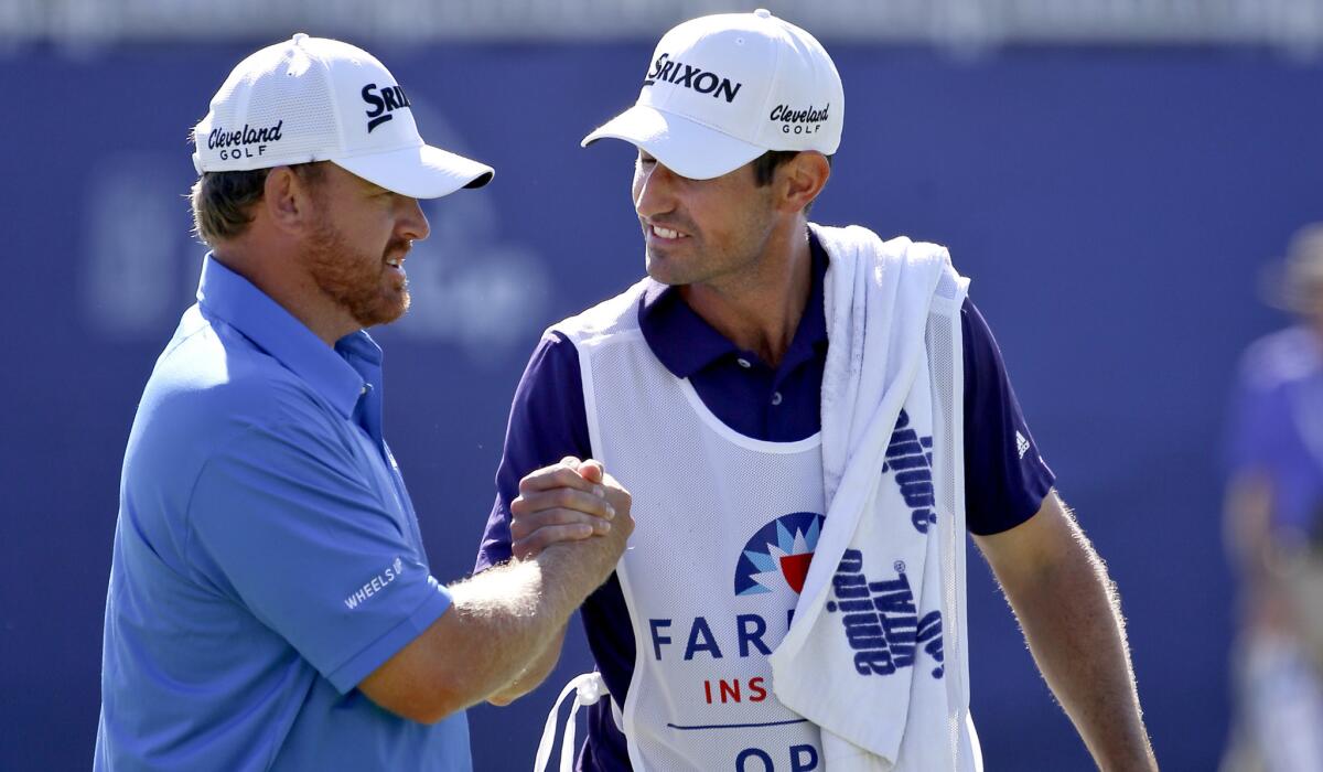 J.B.Holmes is congratulated by his caddie Brandan Parsons after getting a birdie at No. 18 to close the third round of the Farmers Insurance Open on Saturday at Torrey Pines.