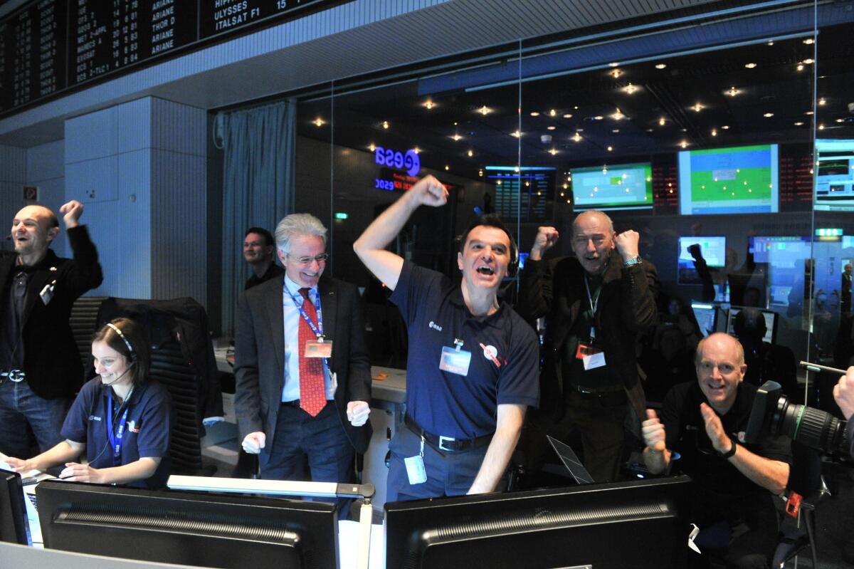 European Space Agency technicians celebrate after receiving a signal from the Rosetta spacecraft that it had emerged from a nearly three-year sleep to resume its comet-tracking mission.