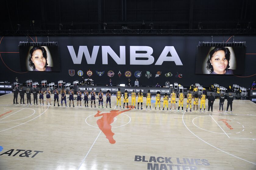 Phoenix Mercury players, left, and Los Angeles Sparks players stand for a moment of silence in honor of Breonna Taylor