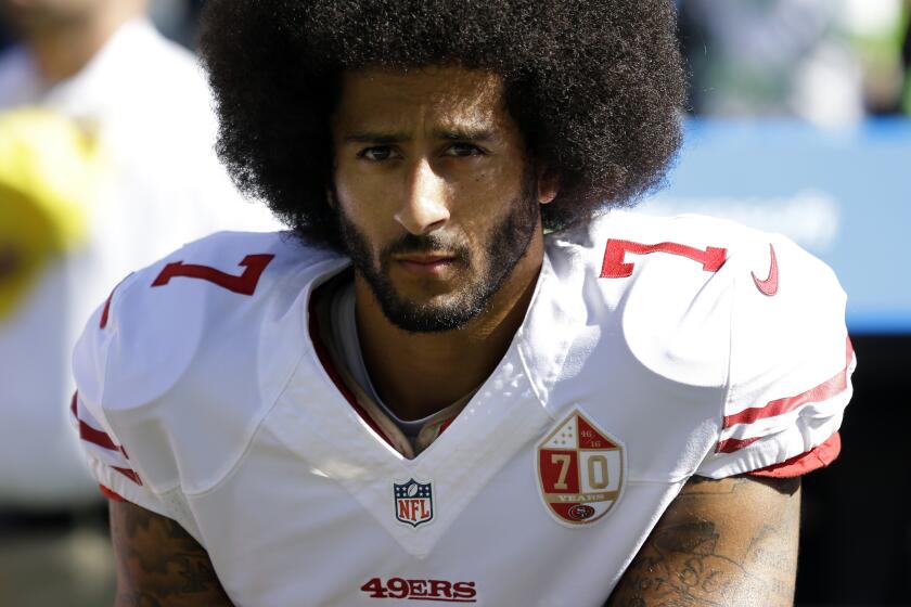 San Francisco 49ers quarterback Colin Kaepernick kneels during the national anthem.