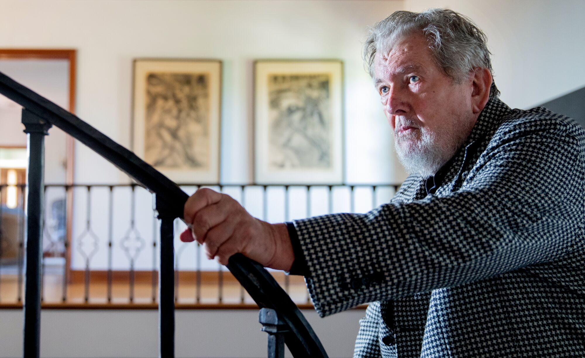 Walter Hill holds a staircase railing at home in Beverly Hills. 