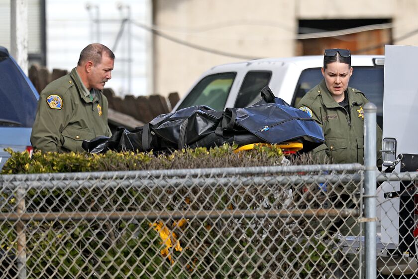 GOSHEN, CA - JANUARY 16: Tulare County Sheriff crime unit removes the body of one of the victims at the scene where six people, including a 6-month old baby, her teenage mother and an elderly woman, were killed in a Central Valley farming community in what the local sheriff said was likely a targeted attack by a drug cartel on Monday, Jan. 16, 2023 in Goshen, CA. The massacre occurred around 3:30 a.m. in and around a residence in the Tulare County town of Goshen near Visalia. (Gary Coronado / Los Angeles Times)