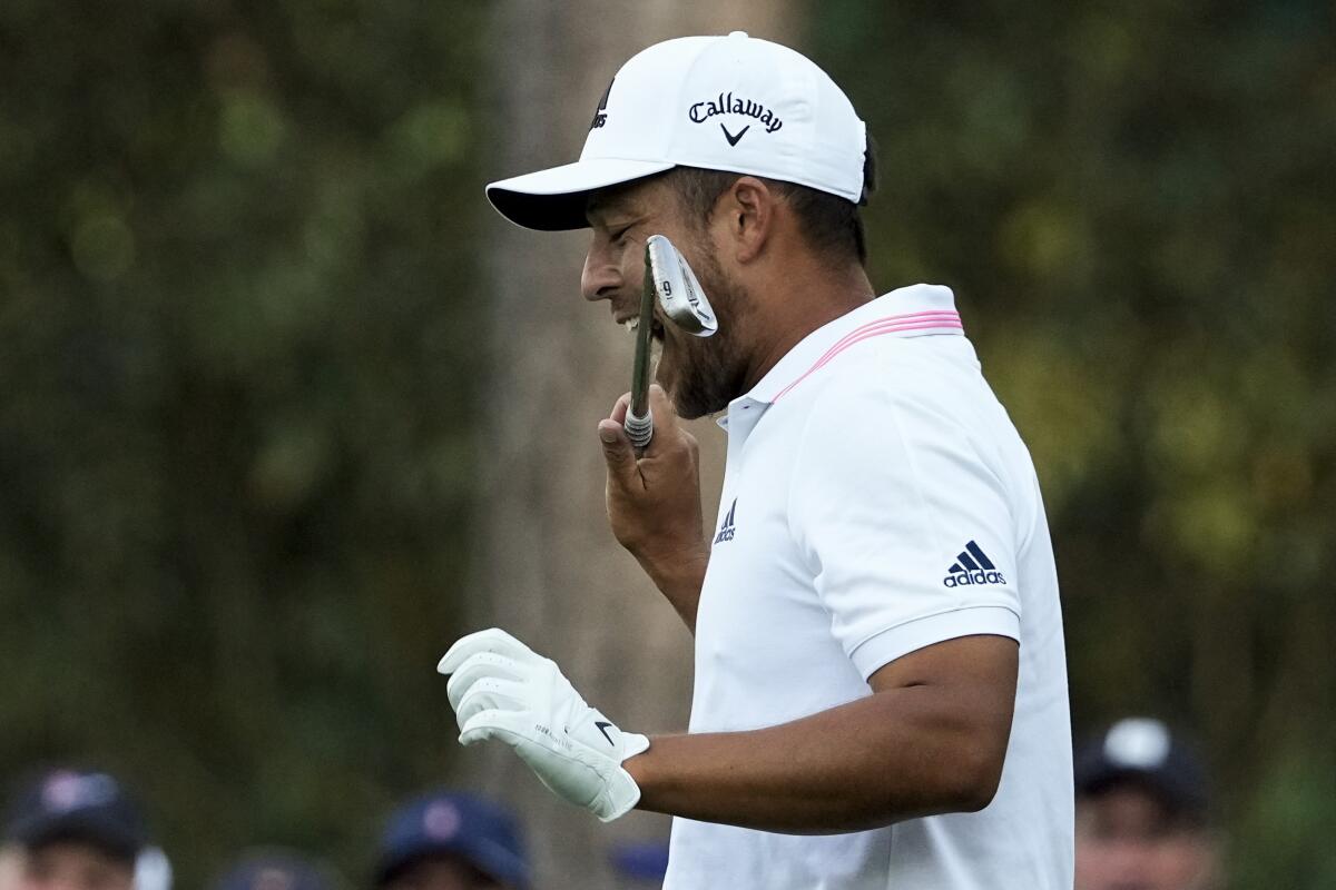 Xander Schauffele bites his club after taking his second tee shot on the 16th hole during the final round.