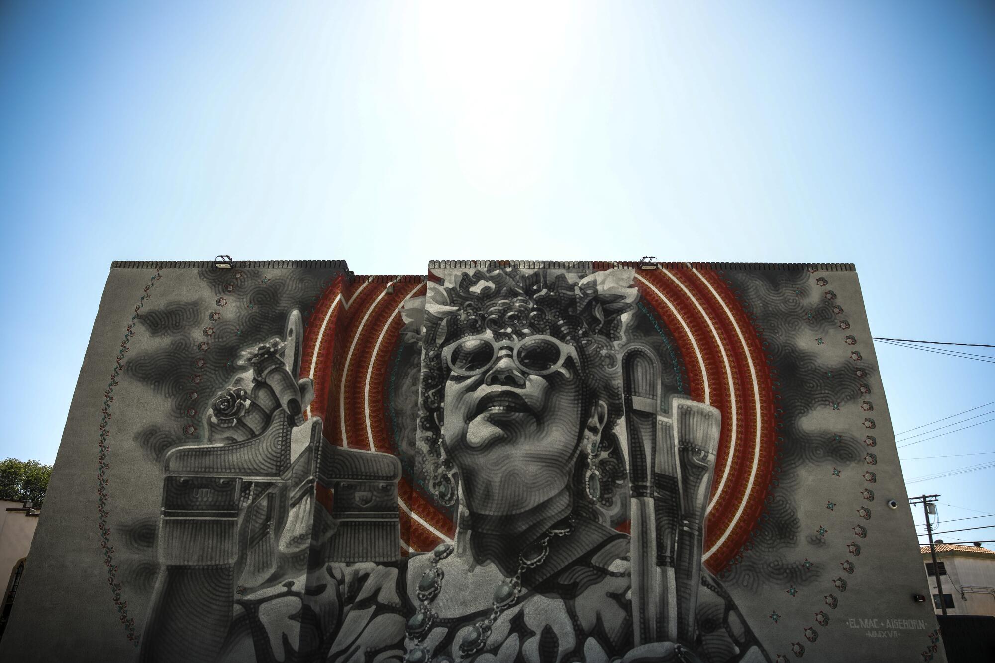A mural by artist El Mac adorns a wall 
