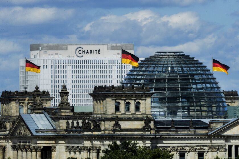 The bed skyscraper of the Berliner Charite can be seen behind the Reichstag building in Berlin, Germany, Tuesday, Aug.25, 2020.. In the clinic the Russian oppositional Nawalny is treated. Doctors of the Berliner Charite assume that the Kremlin critic was poisoned. (Christoph Soeder/dpa via AP)