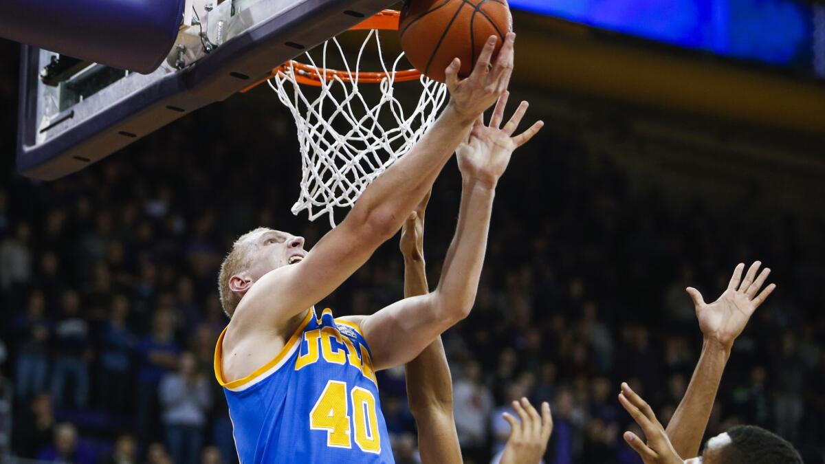 UCLA center Thomas Welsh (40) attempts a reverse layup against Washington in the first overtime Friday.