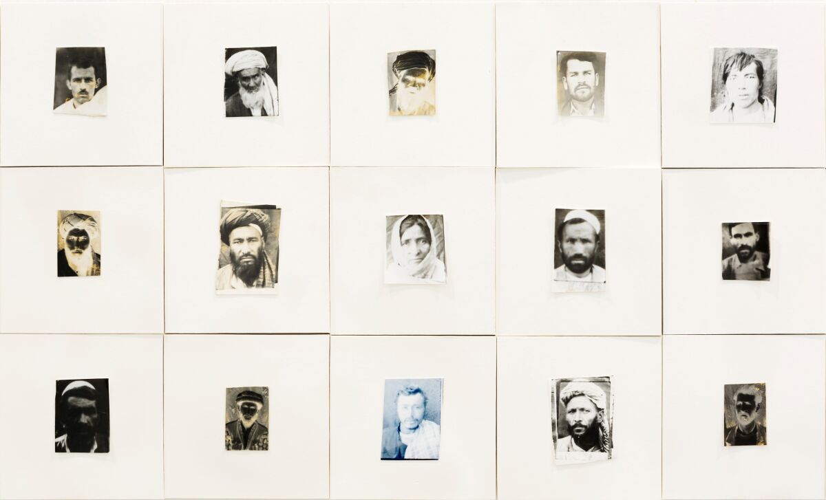 Rows of photos framed in big white mats reveal the weary faces of Afghan citizens during the war