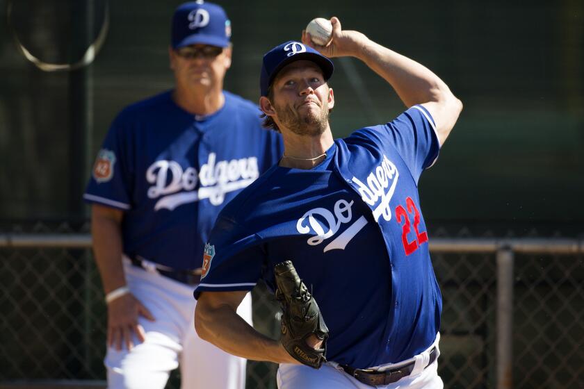 Dodgers ace Clayton Kershaw warms up under the watch of pitching coach Rick Honeycutt before throwing live batting practice Saturday at Camelback Ranch.