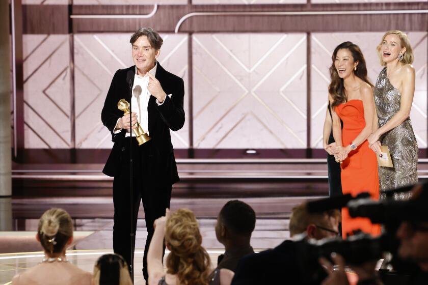Esta imagen proporcionada por CBS muestra a Cillian Murphy aceptando el premio al mejor actor en una película por su papel en "Oppenheimer" durante la 81ª edición de los Globos de Oro en Beverly Hills este domingo. A su lado posan Michelle Yeoh y Naomi Watts.